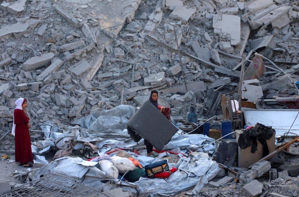 Palestinians inspect what is left of a destroyed house.