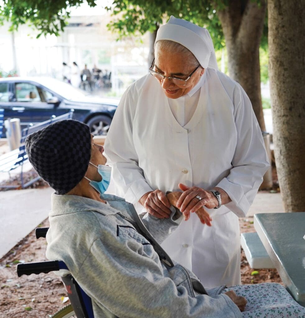 Sister Therese Abou Nassif, speaks with a patient in the hospital’s courtyard.