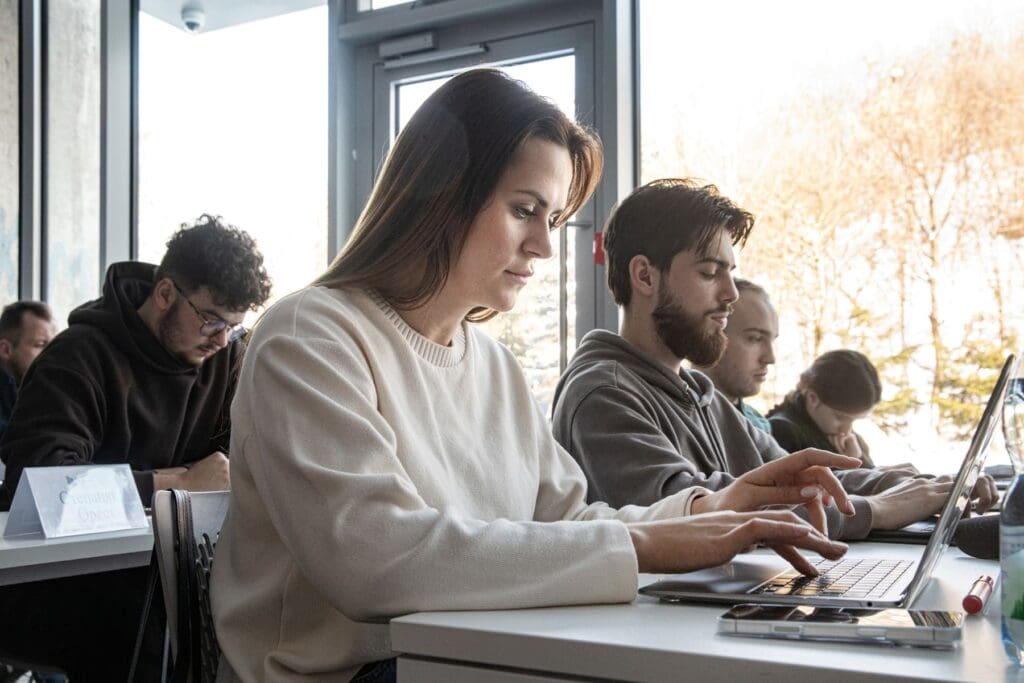 A woman using a laptop in a classroom.