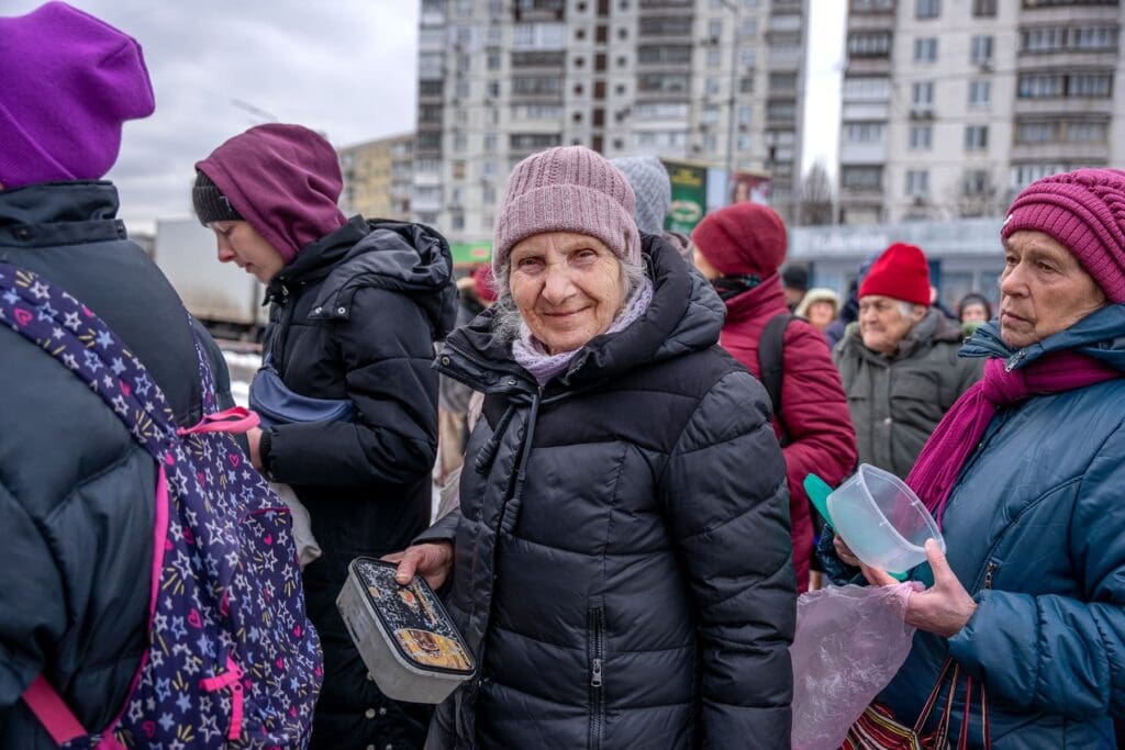 People stand in line for a warm meal, Ukraine.