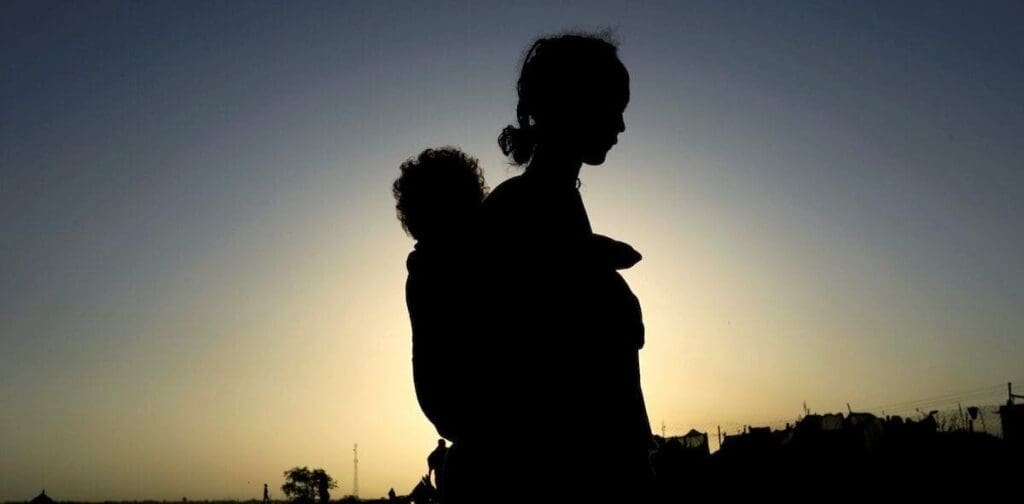 Silueta de una madre cargando a su hijo sobre la espalda.