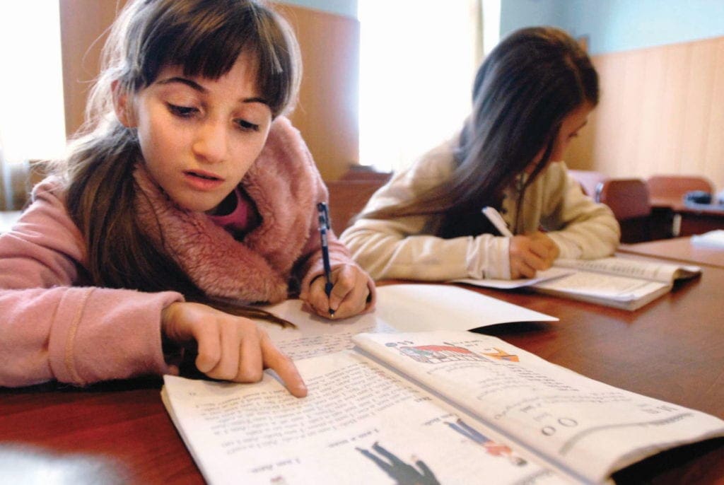 Las niñas estudian en una mesa grande.