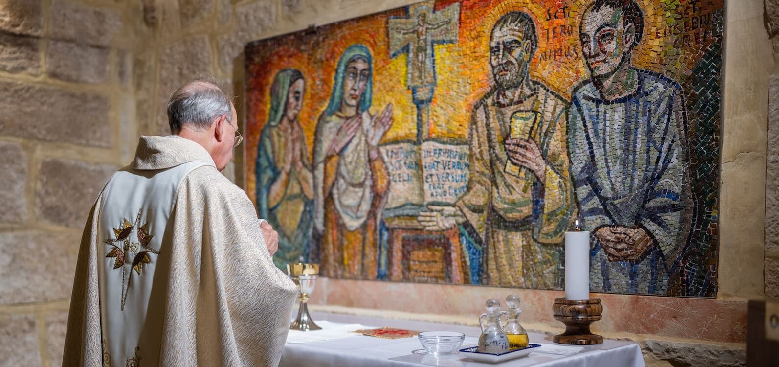 La imagen muestra la espalda de un sacerdote celebrando la misa.