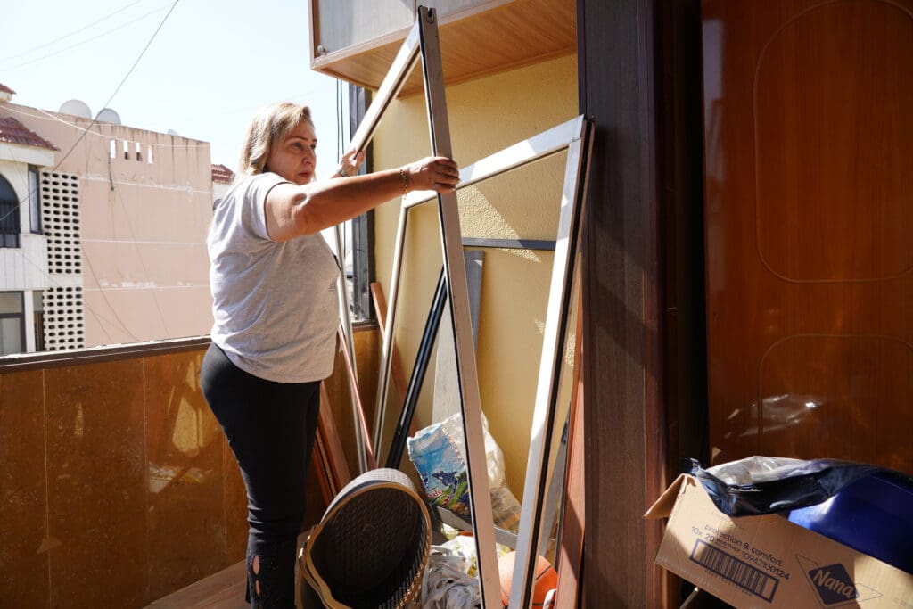 Una mujer sostiene marcos de ventanas.