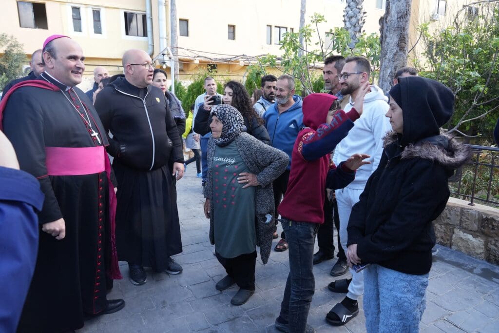 El arzobispo Paolo Borgia se reúne con familias cristianas en una calle.