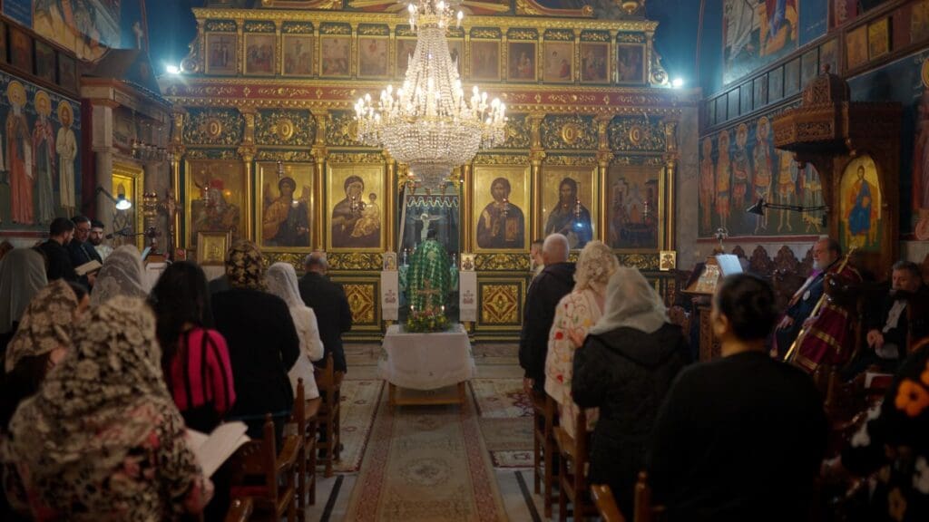 Un sacerdote con vestiduras verdes celebra una liturgia en una iglesia ortodoxa griega.
