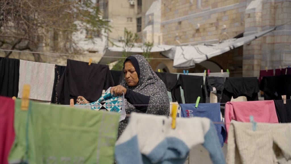 Una mujer musulmana en medio de un tendedero de ropa.