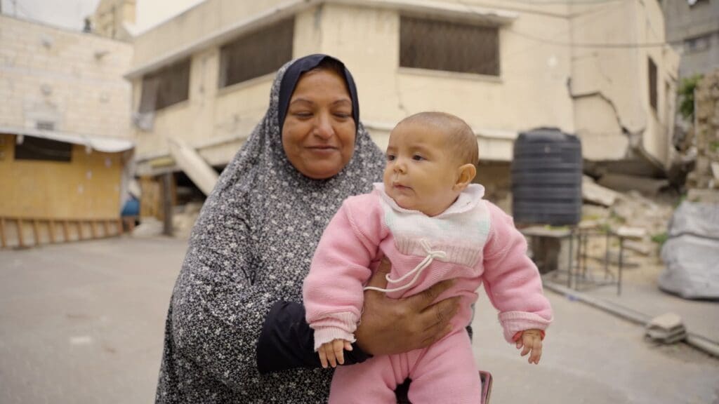 Una mujer musulmana sostiene a una bebé.