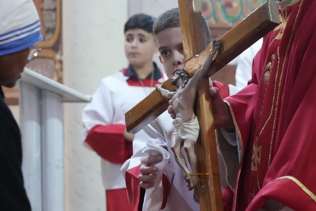 Un monaguillo sostiene un crucifijo para venerar durante el Viernes Santo.