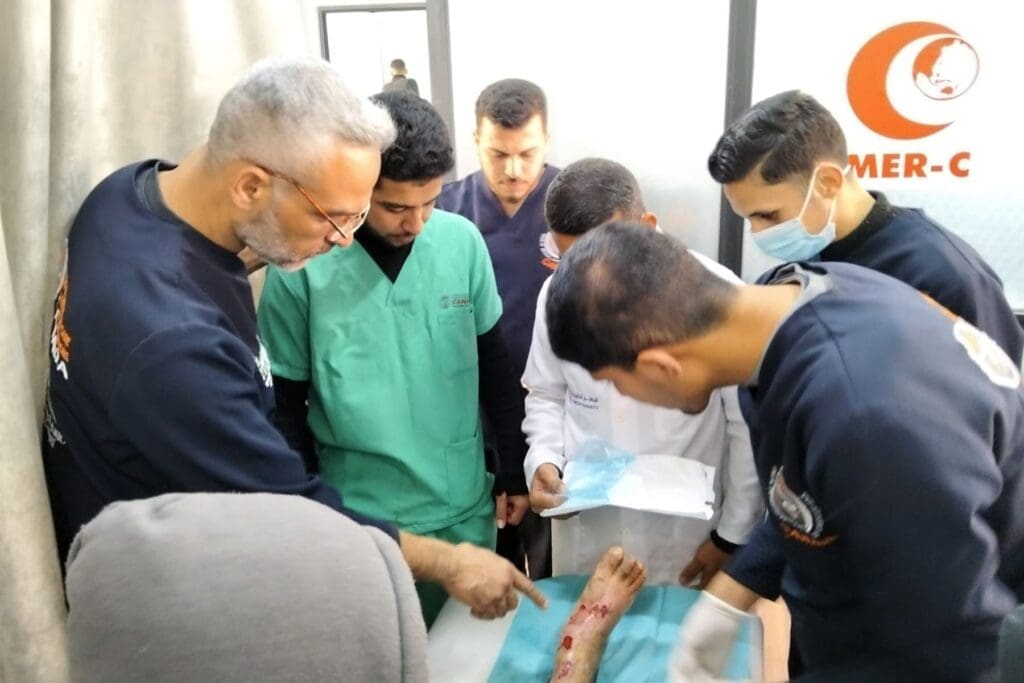 Un grupo de médicos examina el pie herido de una mujer.