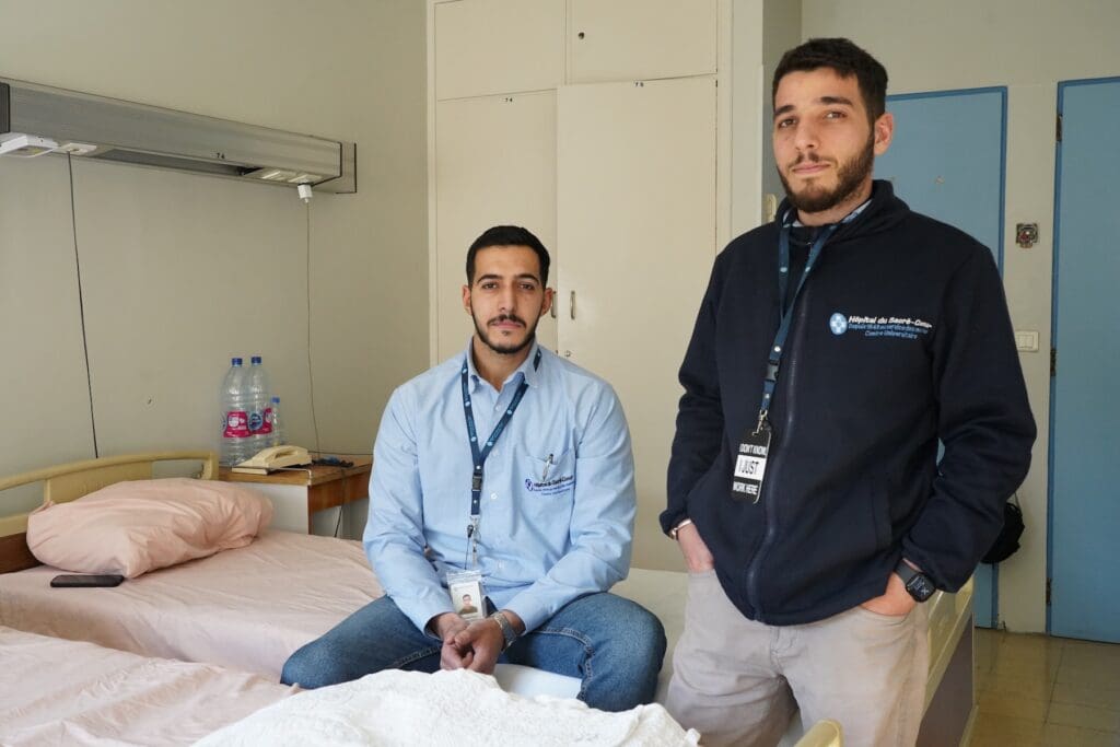 Una fotografía de dos hombres, uno de ellos está sentado.