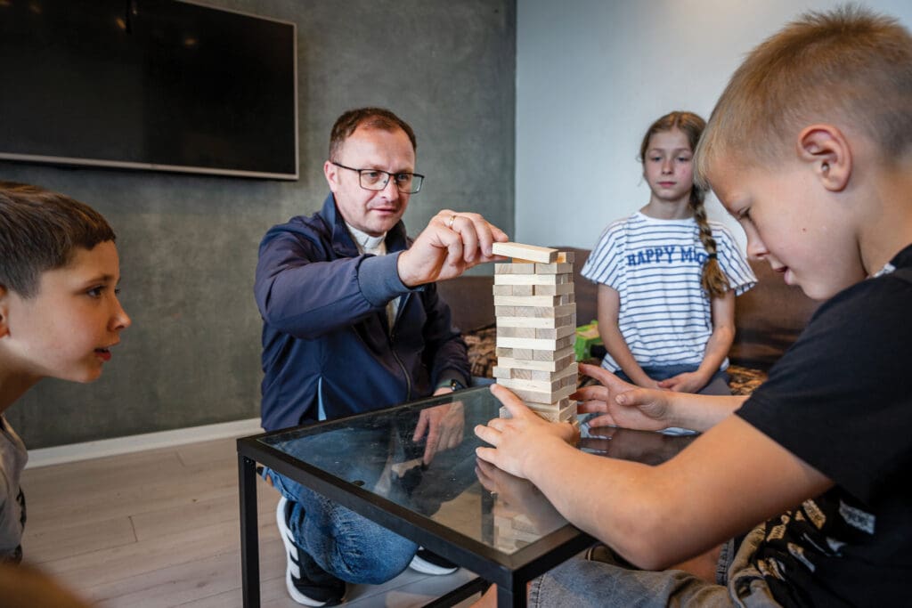 Un sacerdote juega al Jenga con niños.