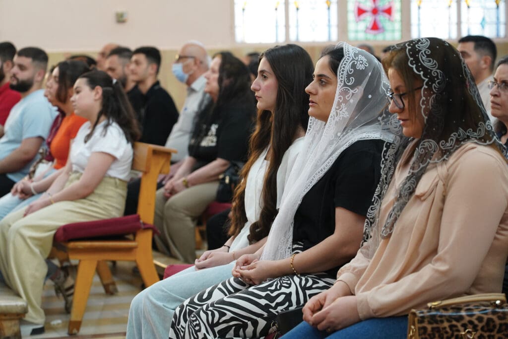 Mujeres sentadas en los bancos de una iglesia.