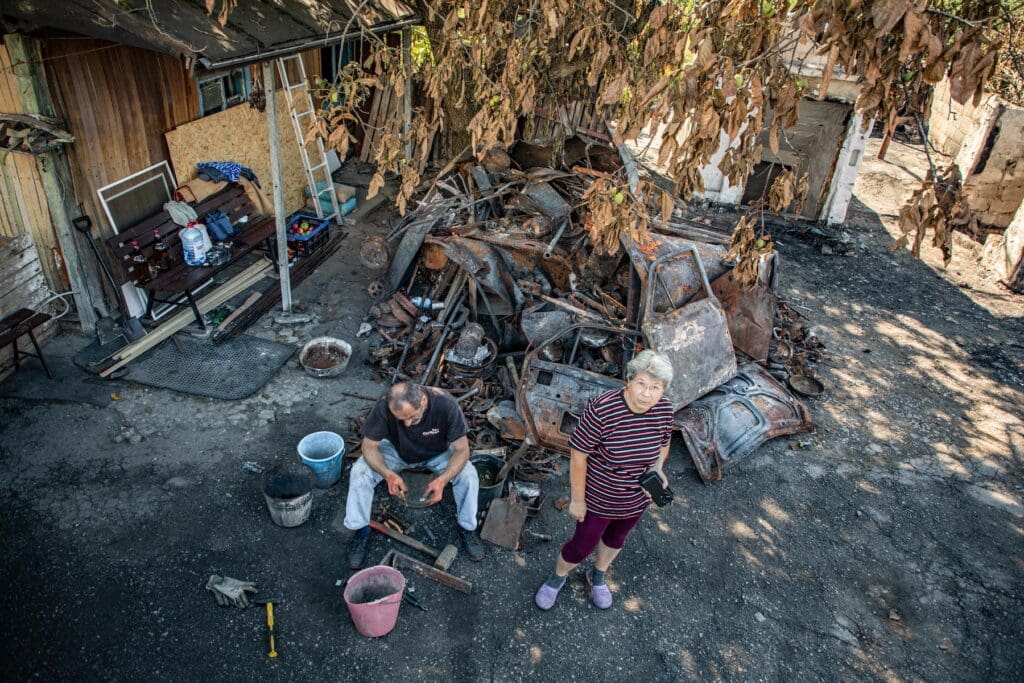 Un hombre y una mujer en medio de un patio lleno de escombros.