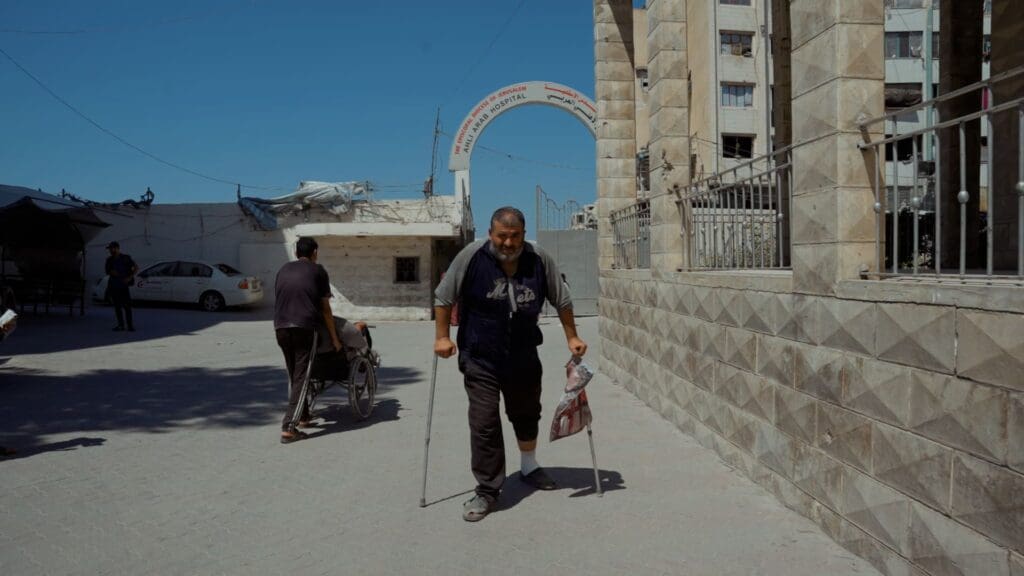 Un hombre en muletas camina por una calle de Gaza.