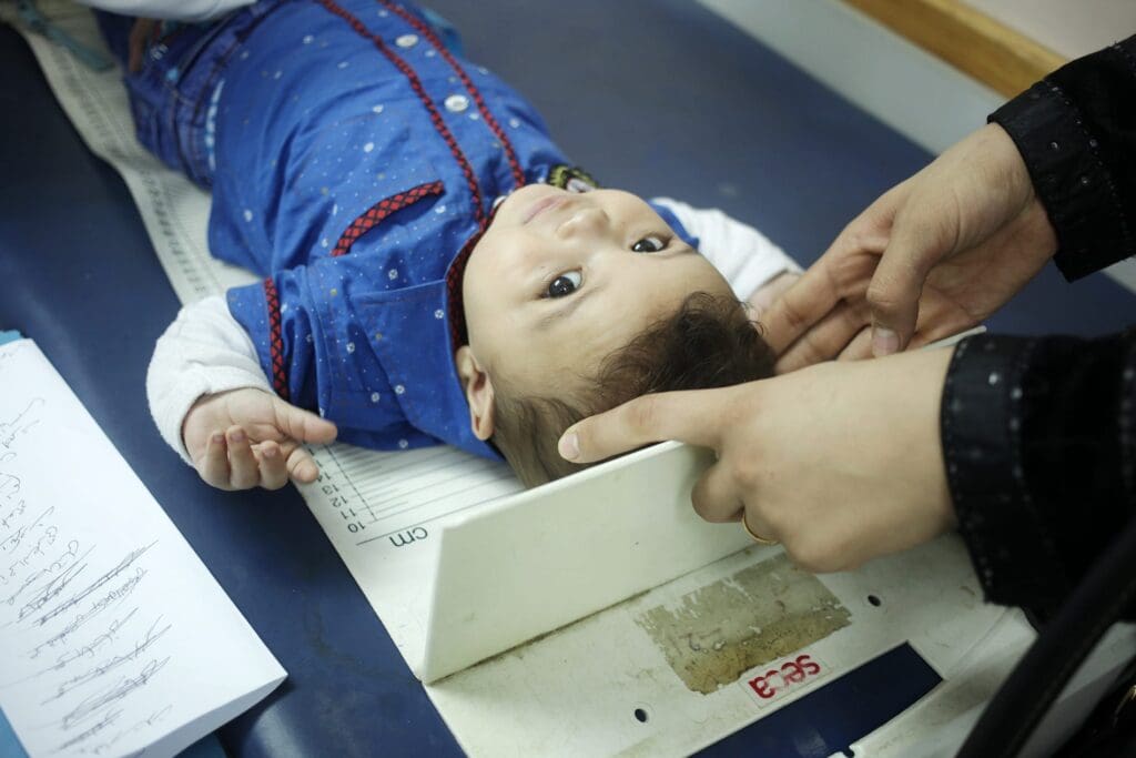 Un bambino piccolo è sdraiato su un lettino da visita.
