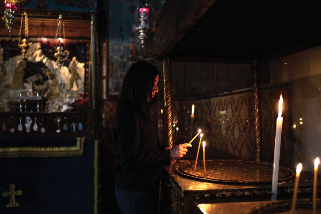 Una donna accende una candela.