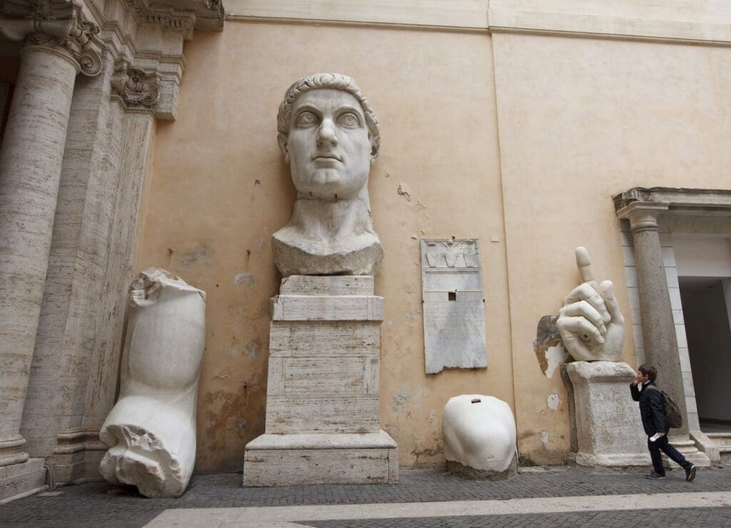 Frammenti di una statua che raffigurano il viso, un braccio e una mano di una colossale statua