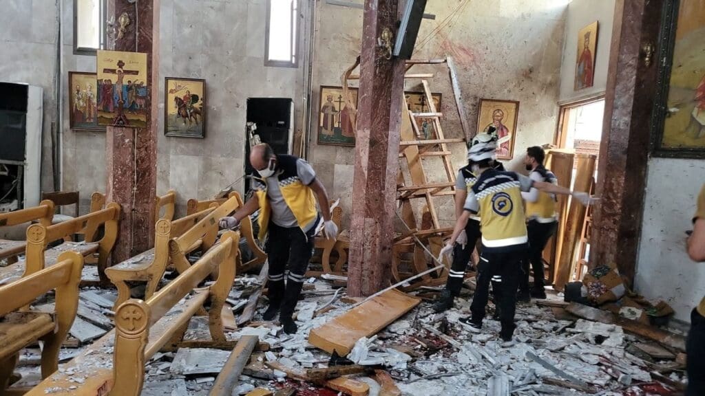 Alcuni uomini verificano i danni all'interno di una chiesa distrutta