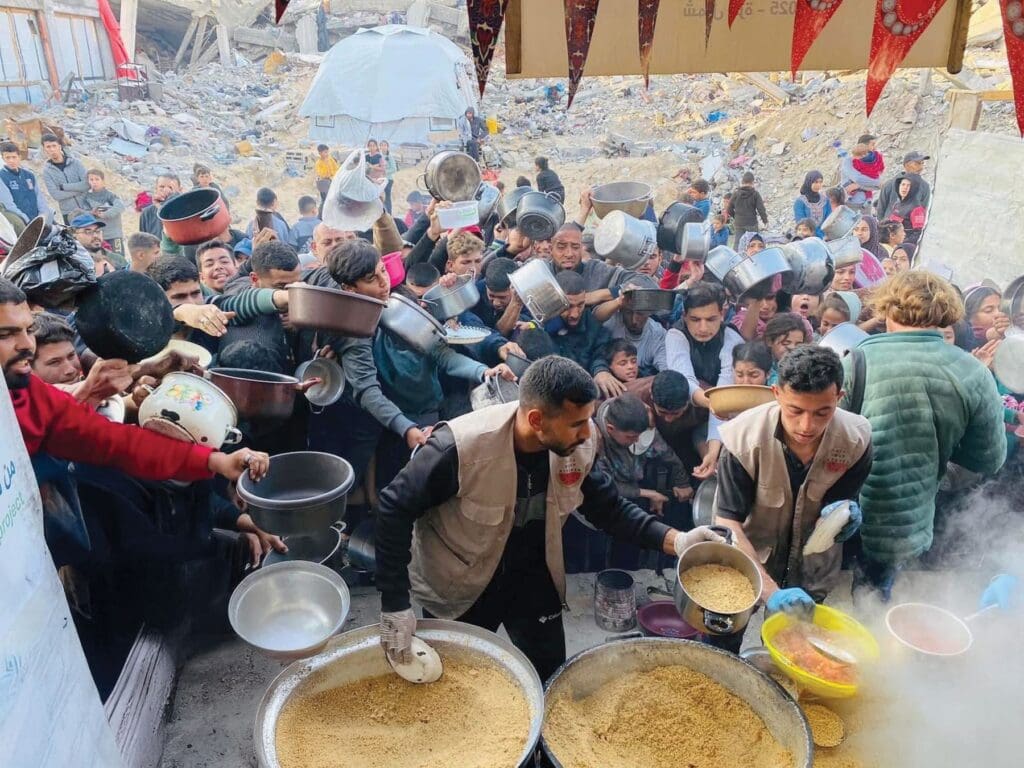 Una folla di persone si accalca per ottenere del cibo.