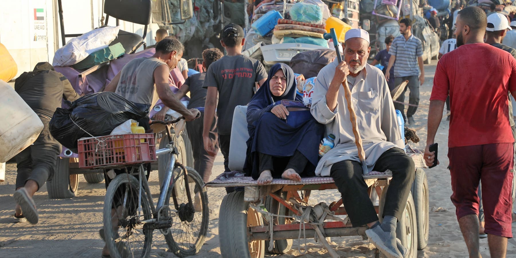 Folla di persone su una strada polverosa.