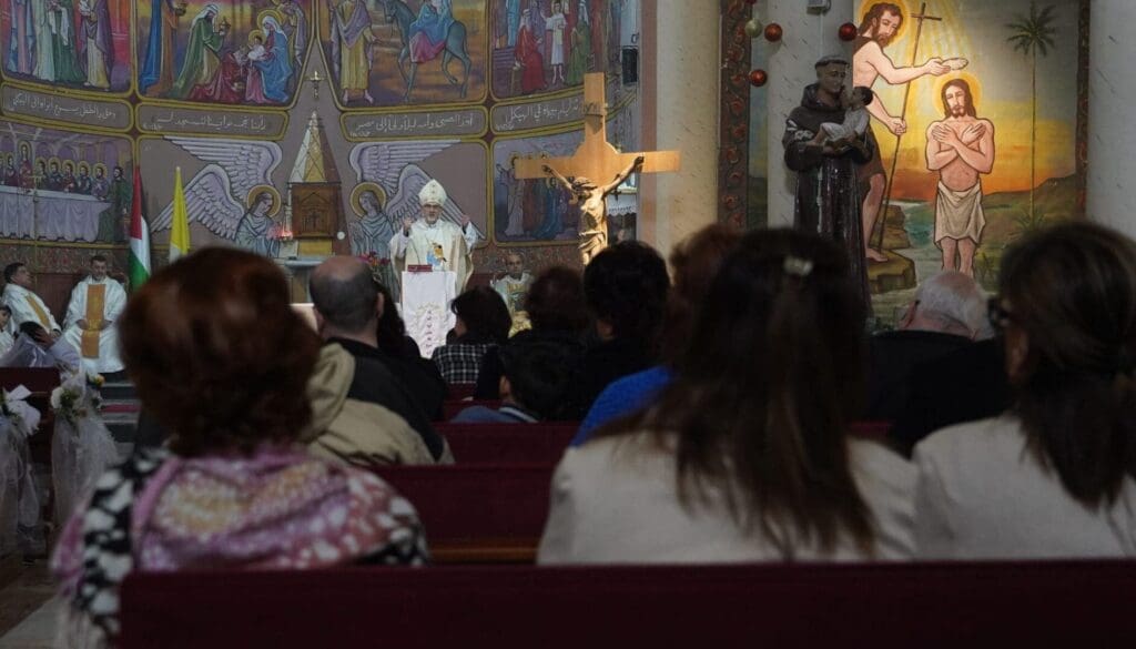 Un religioso che parla ad un leggio in una chiesa davanti a tanta gente.