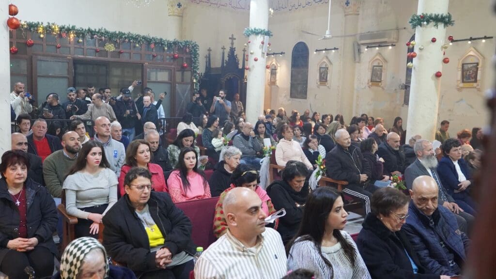 Gruppo di fedeli seduti in una chiesa ortodossa