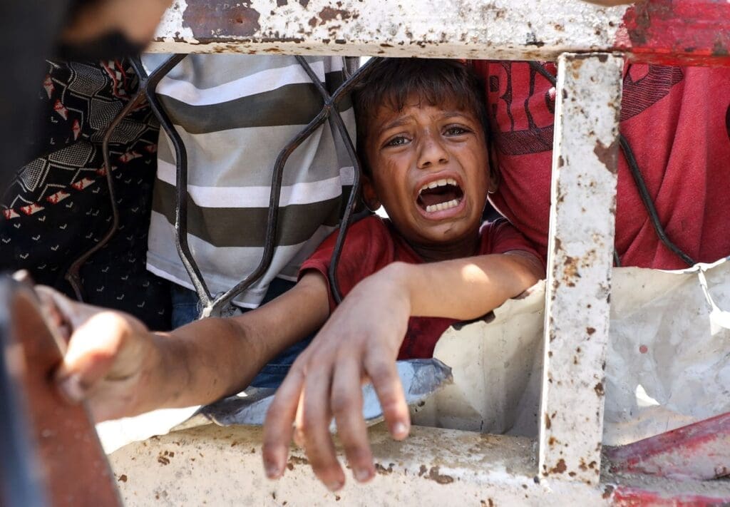Primo piano intenso di un bambino a Gaza che piange per la fame.