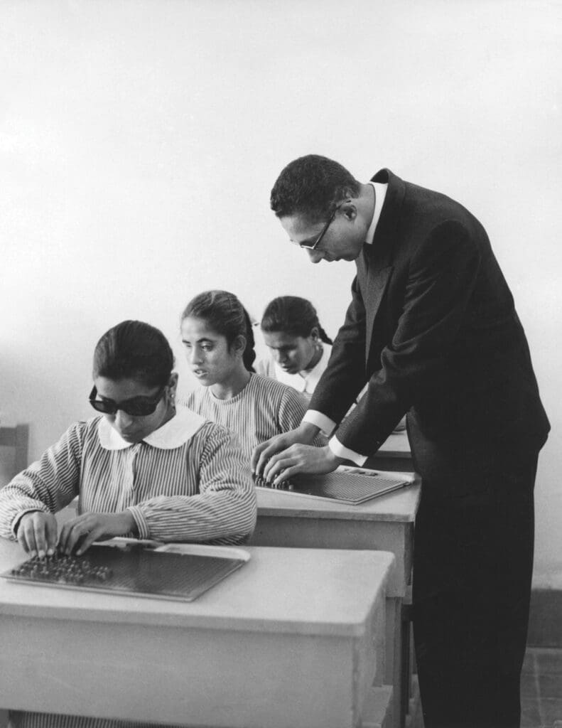Un insegnante con alcuni studenti non vedenti.