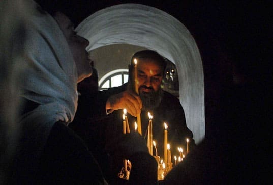 Un uomo accende una candela