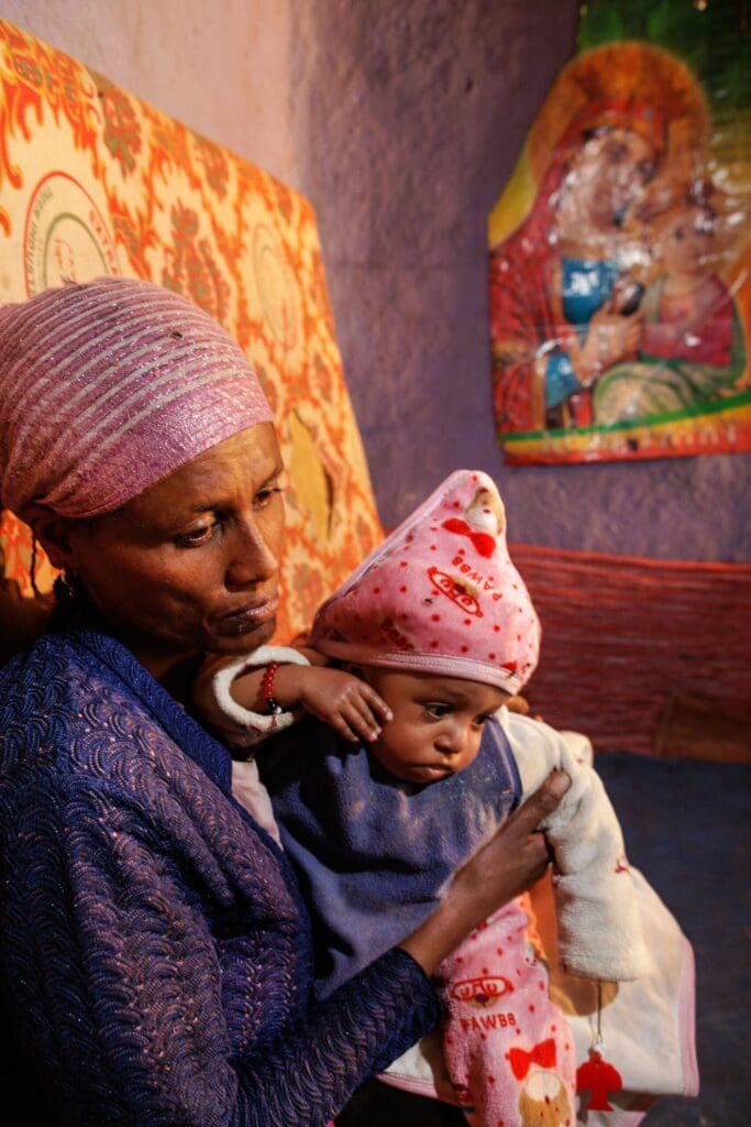 Una donna con un bambino in braccio.