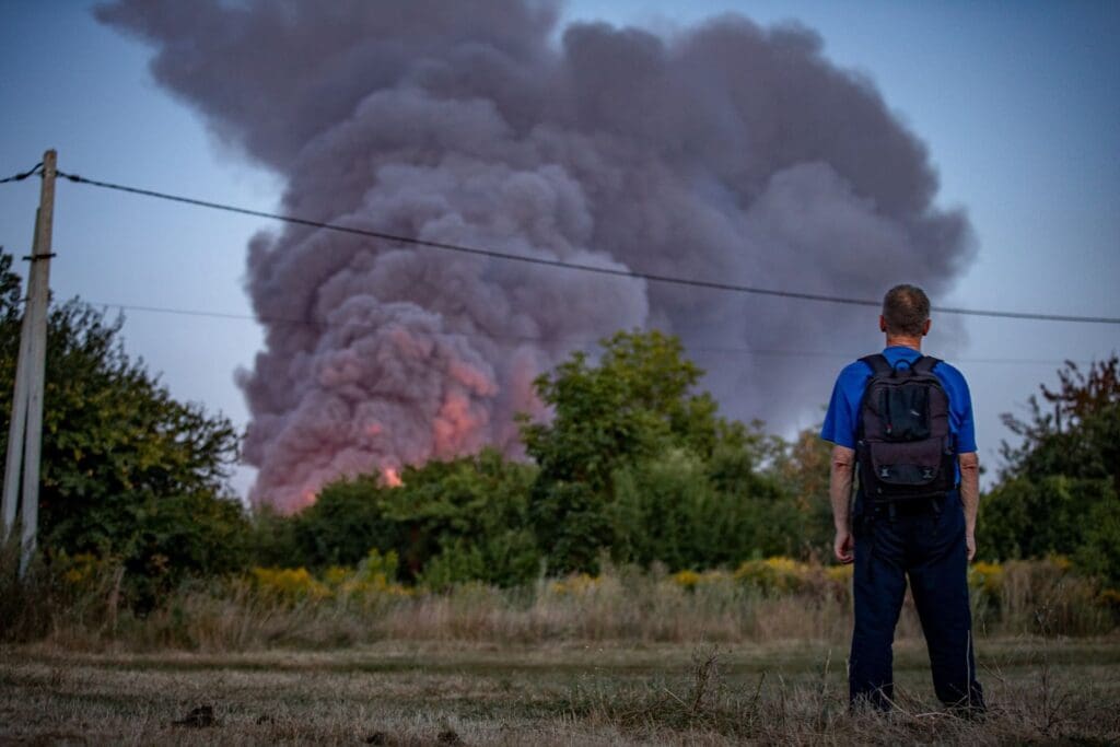 Un uomo osserva un incendio.