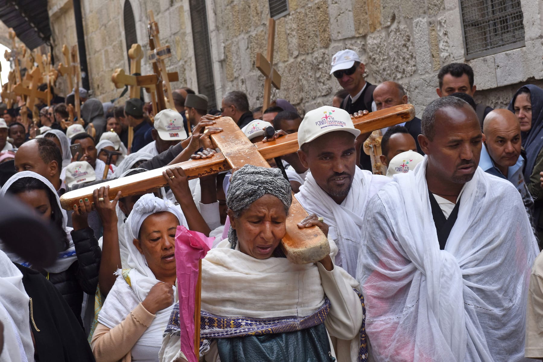 Christians from Ethiopia carry cross during procession Via Dolorosa in Jerusalem