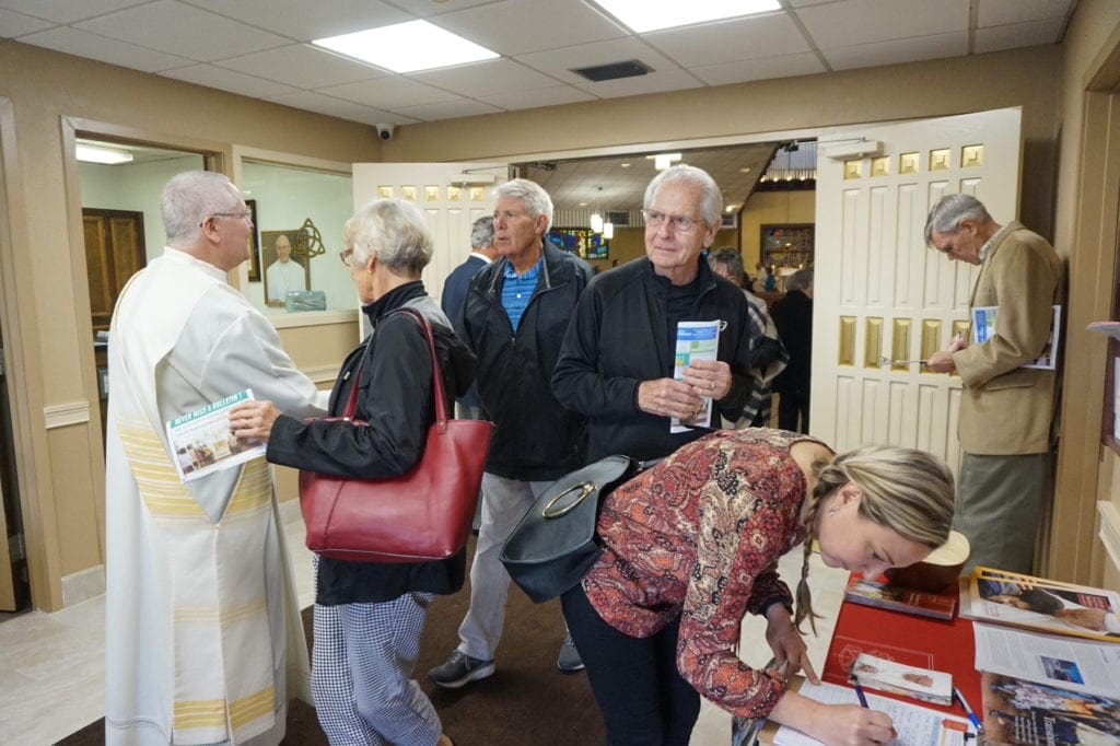 Deacon Greg Kandra greets several parishioners.