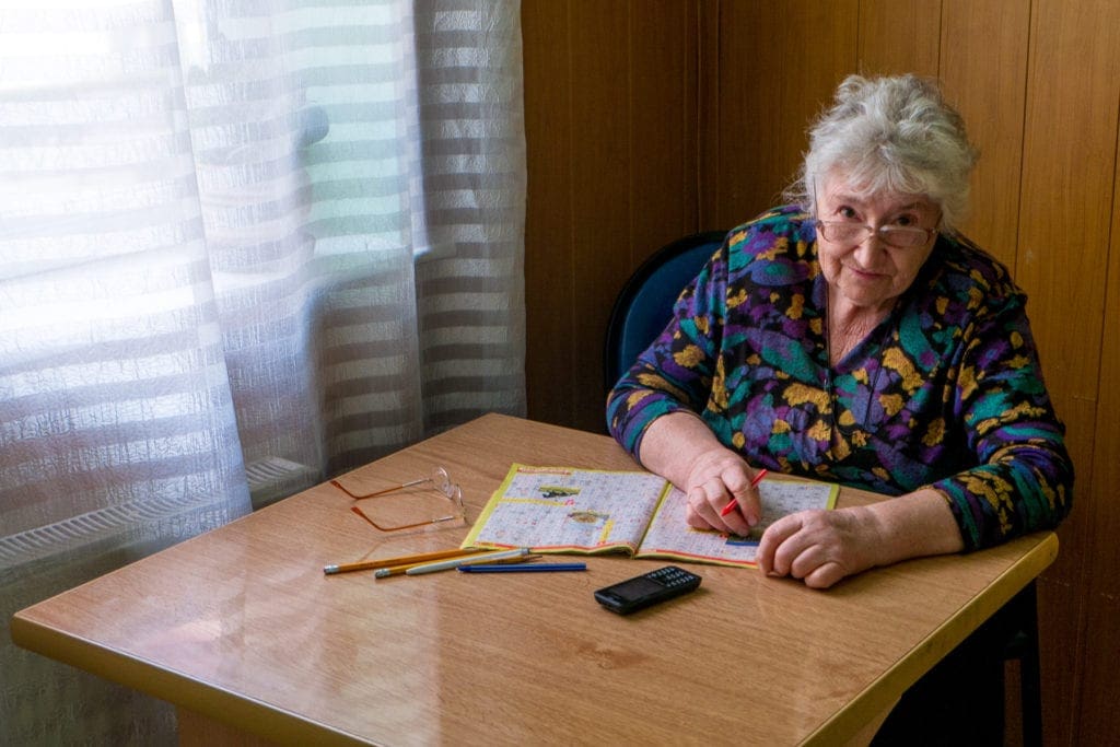 an elderly guest reads in the Harmony Day Center.