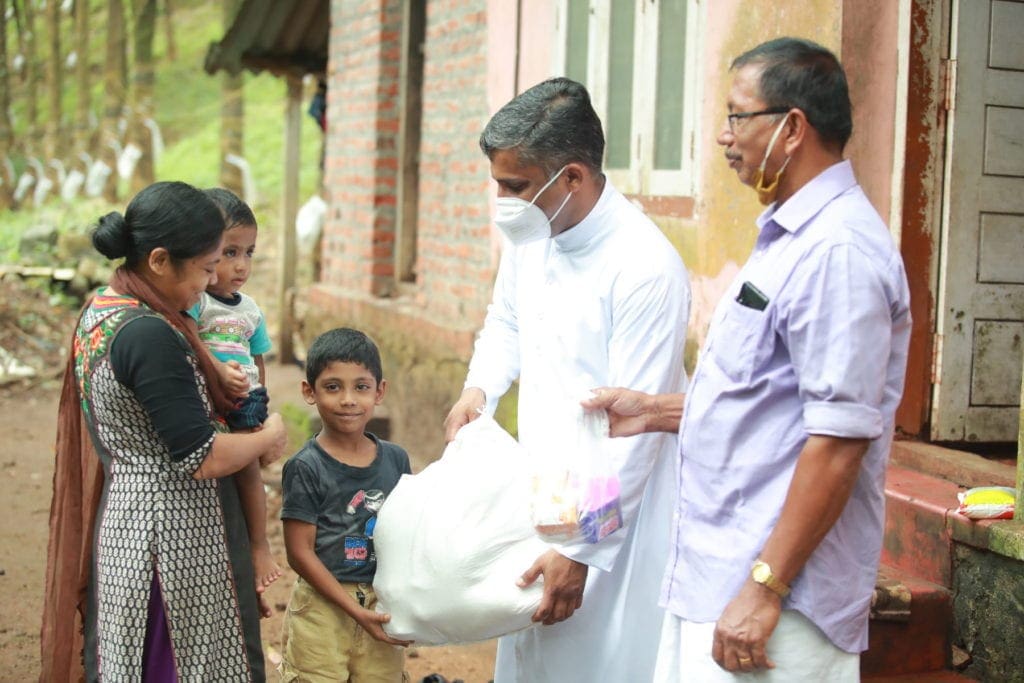 a pair of church workers deliver parcels to a family.