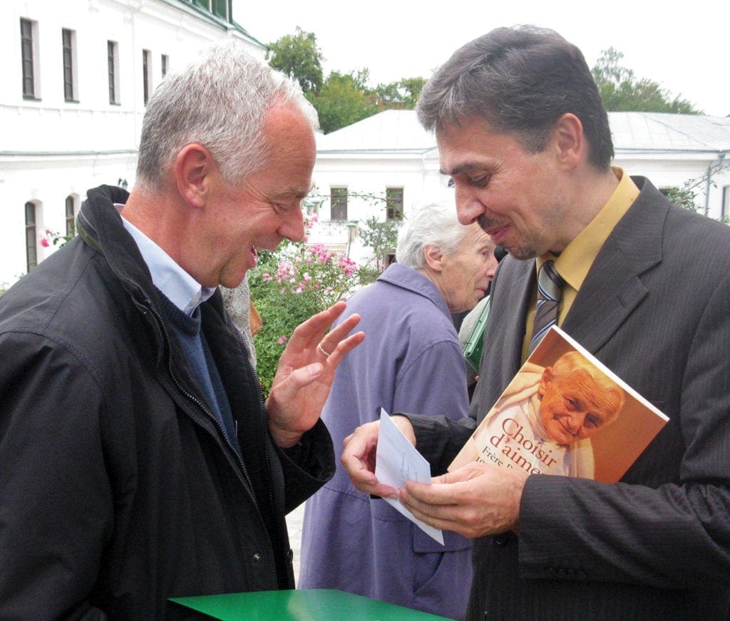 a man offers another man a book.