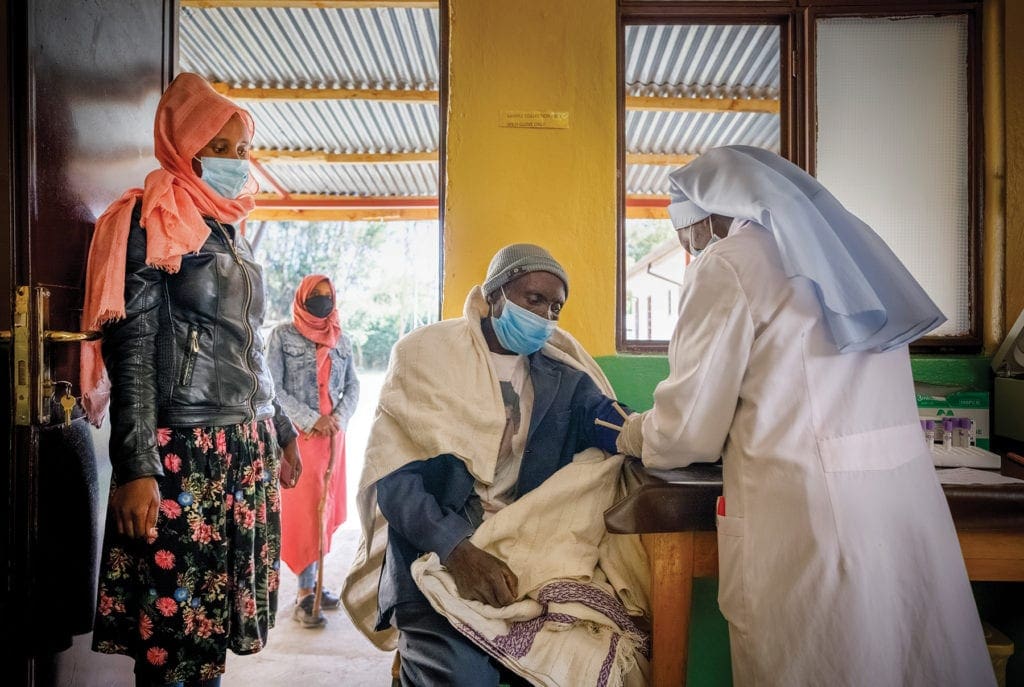 a nun performs triage in a clinic.