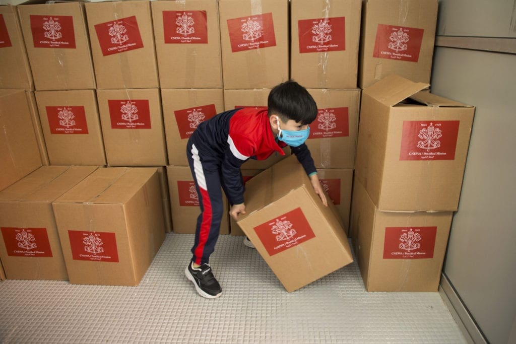 boy handles food boxes in Lebanon