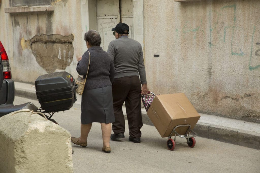 elderly couple walks home with food box in Lebanon