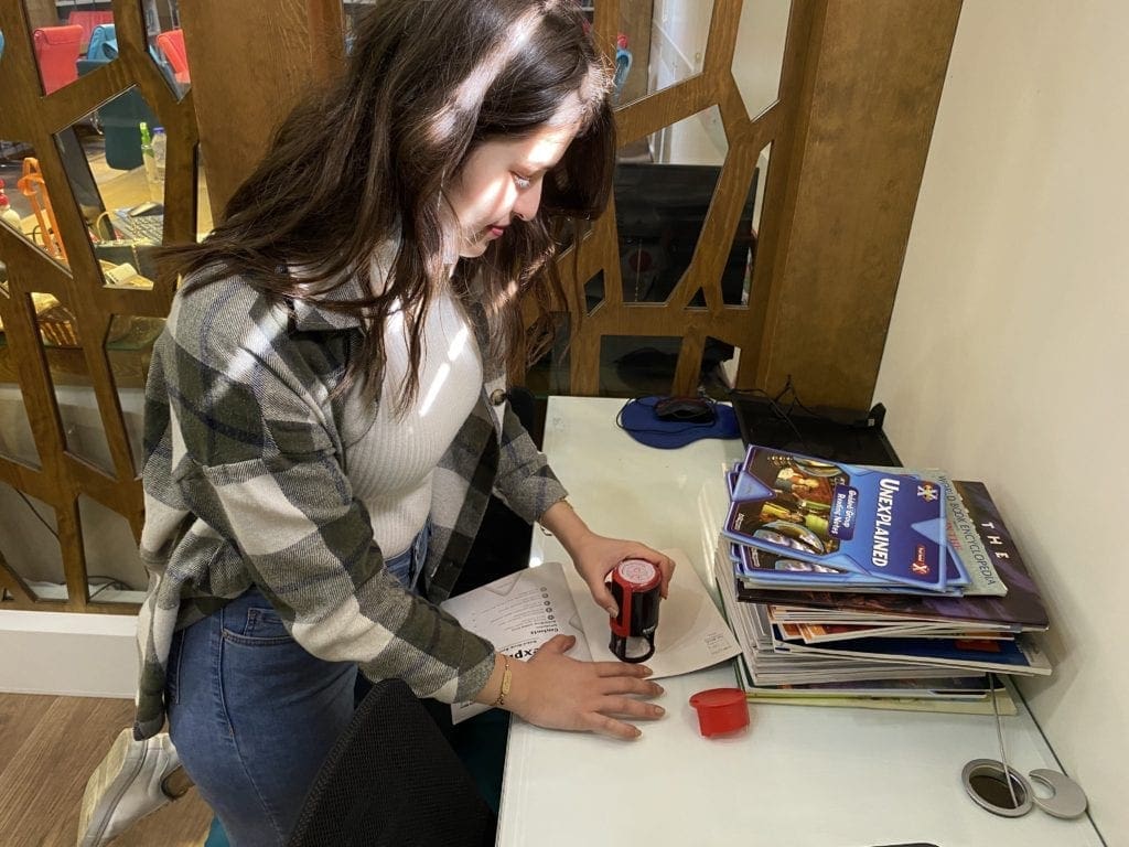 A volunteer prepares English language resources for her tutoring session