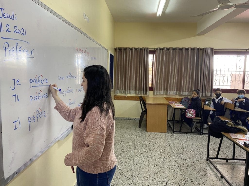 A volunteer teaches a lesson on French verbs at Rosary Sisters School in Gaza