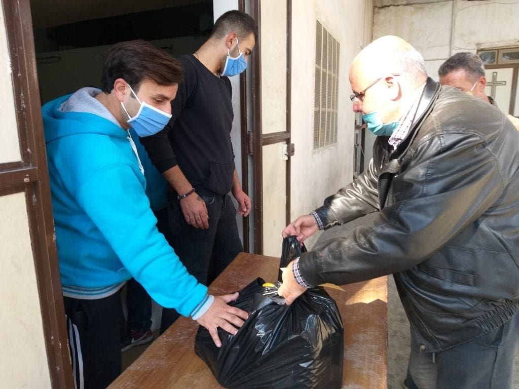 Man receives food packages at the Marist Brothers' Center in Aleppo