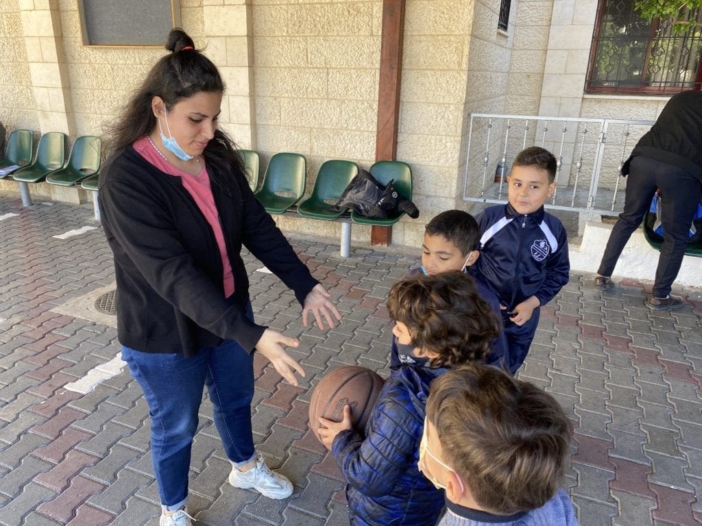 A volunteer teaches students at Rosary Sisters School language skills through games