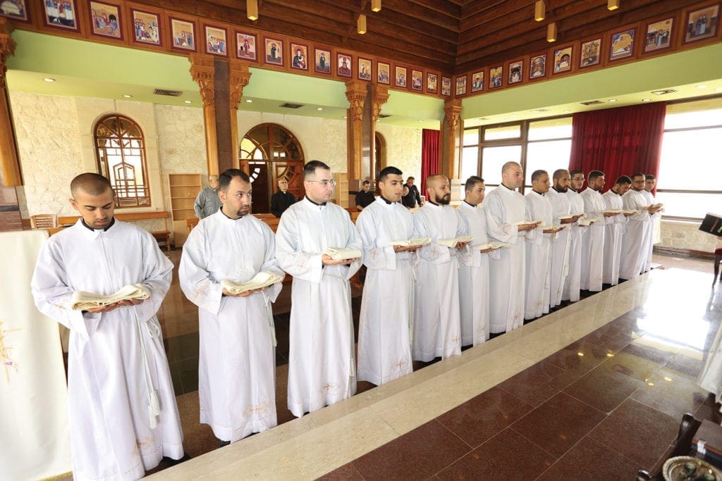 seminarians stand in a line to receive a blessing.