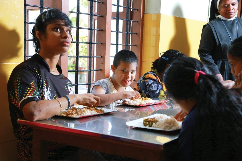 young women eat lunch at a long table.