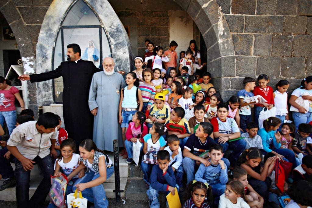 a bishop meets with a group of schoolchildren in Syria.