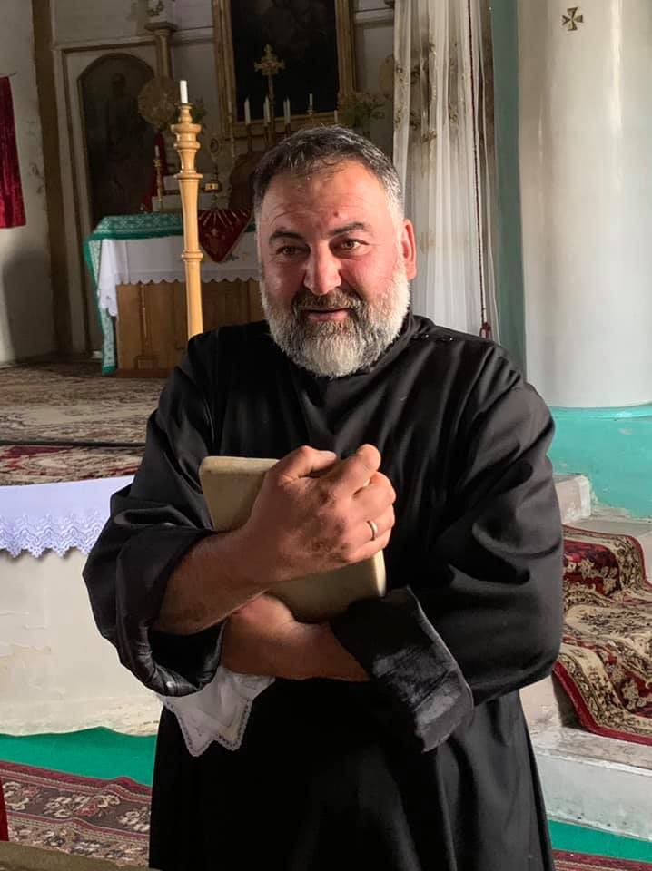 Ter Anton, the pastor of the Armenian Catholic parish in Eshtia, Georgia, clutches onto an altar stone.