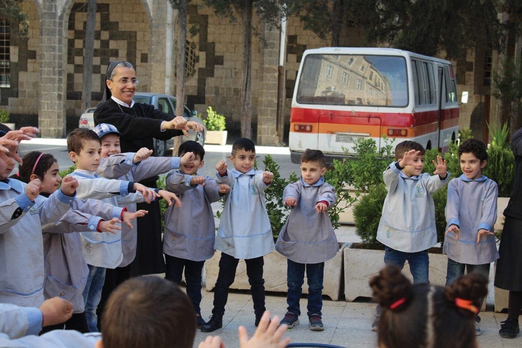 a nun and children play games outside.