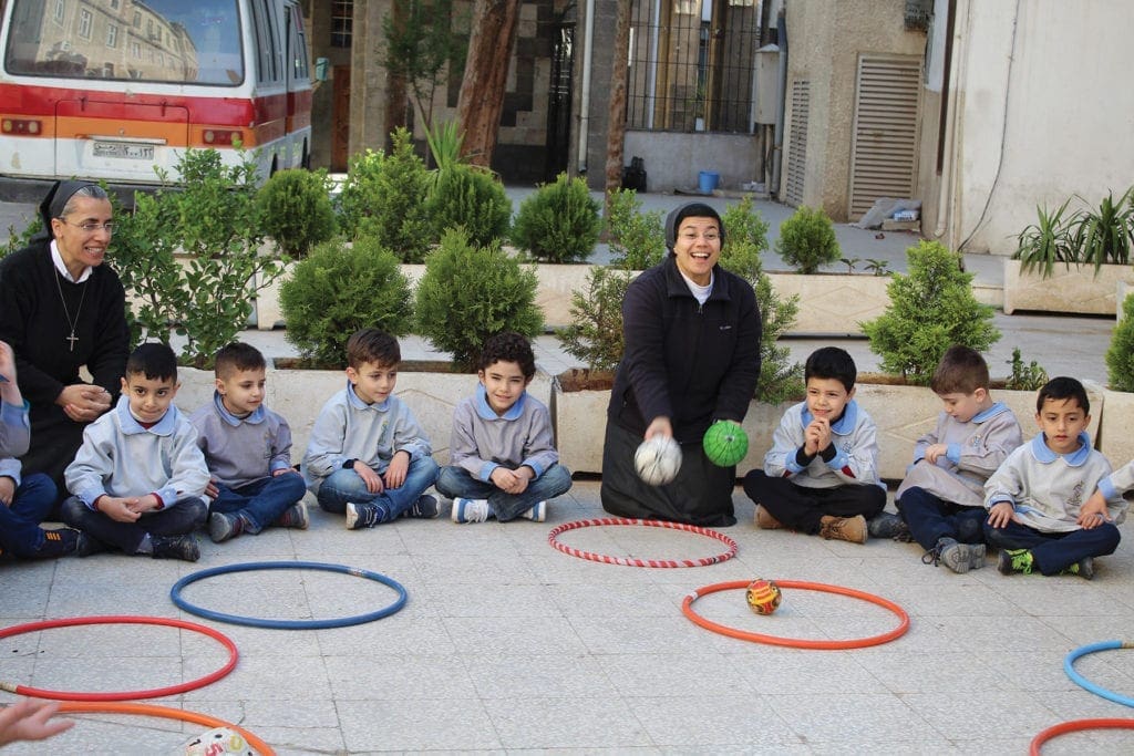 nuns play games with children outside.